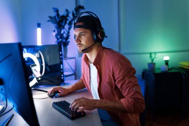 istock Young handsome concentrated man with headset playing video games at night 1492971949