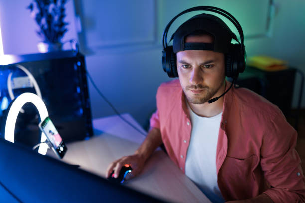 istock Young handsome concentrated man with headset playing video games at night 1492971950