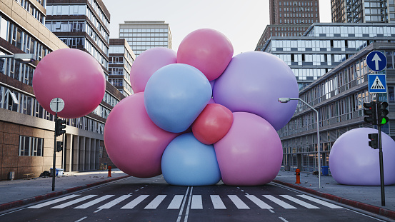 A cluster of big soft multi colored spheres in the middle of the city street, 3D render