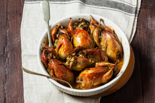 istock Baked quail stuffed with mushrooms, eggs and bread in a ceramic form on a wooden table. 1492985937