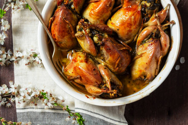istock Baked quail stuffed with mushrooms, eggs and bread in a ceramic form on a wooden table. 1492986394