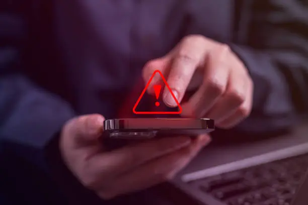 Photo of People with warning notification and spam message icon on mobile phone