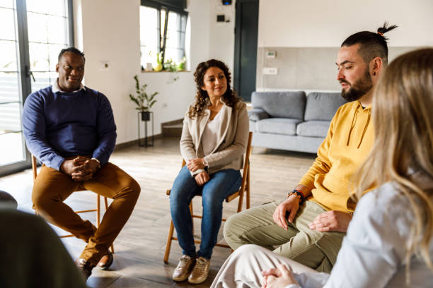istock Group of people sitting in circle, talking during group therapy 1492991996