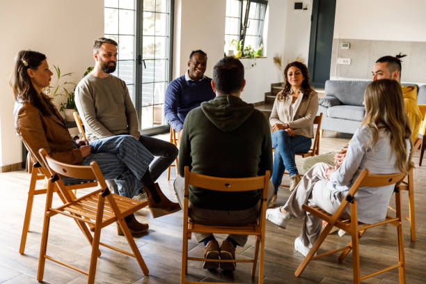 istock Group of people sitting in circle, talking during group therapy 1492992020