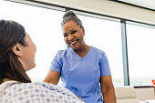 Female patient and female nurse smile at each other