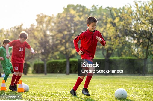 istock soccer players go around the cones with the ball 1492994495