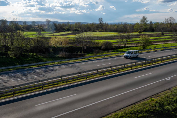 white modern delivery small shipment cargo courier van moving fast on motorway road to city urban suburb. - van moving van commercial land vehicle truck imagens e fotografias de stock