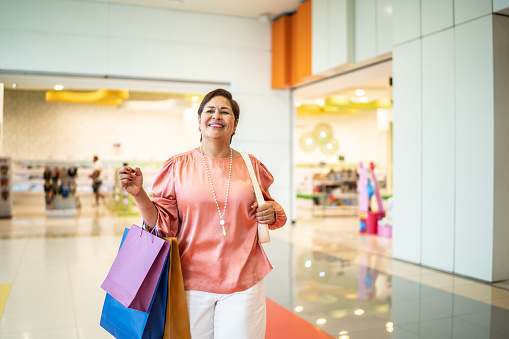 Mature woman walking with shopping bags on a mall