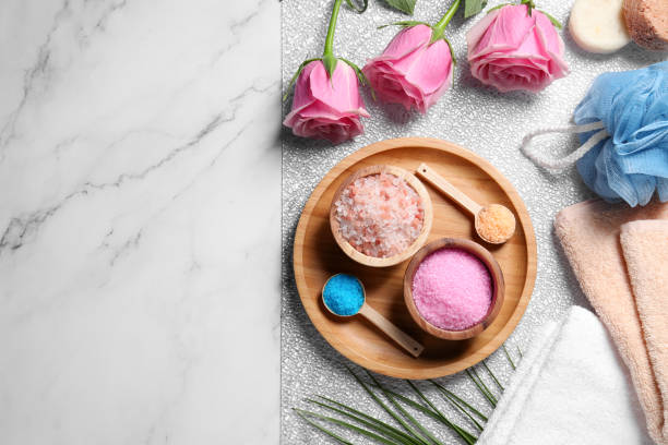 istock Flat lay composition with natural sea salt and beautiful roses on white marble table. Space for text 1493000911