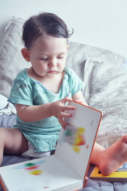 istock Toddler reading a book in bed 1493000953