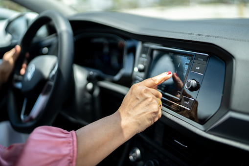 Close-up of woman using car GPS navigation or changing radio music inside a car