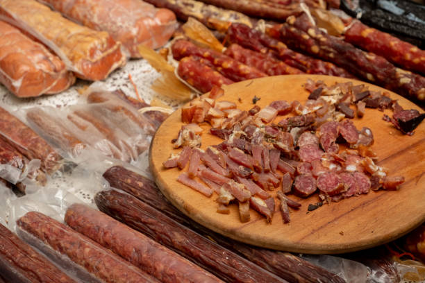 primo piano pezzi di salumi in mostra per la degustazione in mostra su una bancarella del mercato - sausage horse meat salami foto e immagini stock