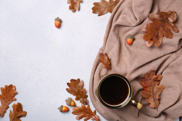 istock Flat lay composition with cup of hot drink and autumn leaves on light grey textured table. Space for text 1493003718