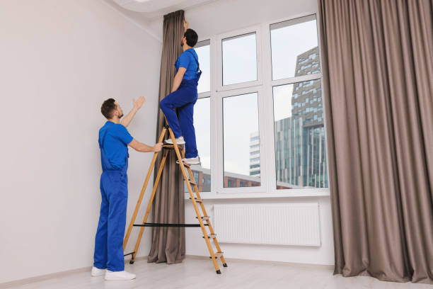 istock Workers in uniform hanging window curtain indoors 1493009235