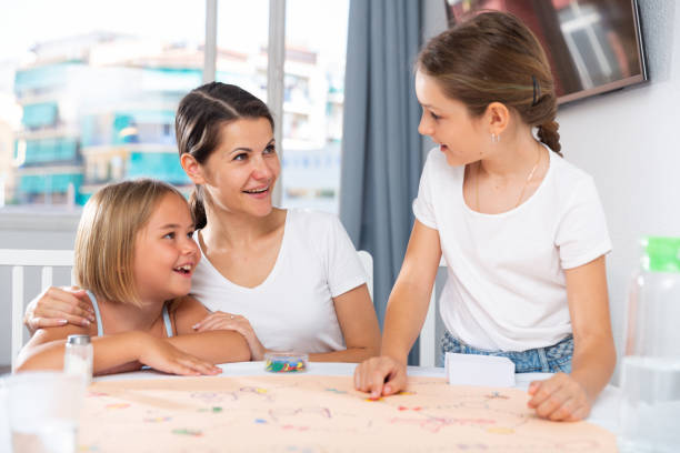istock Woman and two daughters playing board games 1493013950
