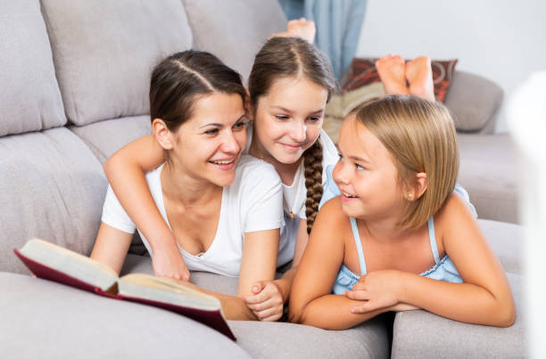 istock Woman reading book to daughters on sofa 1493014015