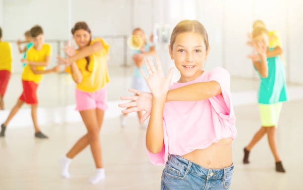 istock Happy tween girl dancing during group class in choreographic studio 1493014188