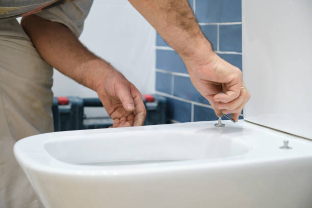 istock Unrecognizable senior plumber installer installing toilet lid. 1493027008