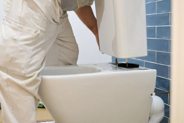 istock Unrecognizable senior plumber installer installing toilet cistern. 1493028420