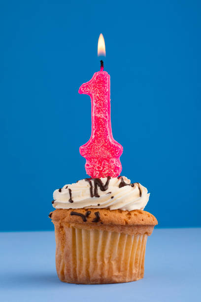 istock Pink number 1 candle - Birthday cake on blue background. 1493029174