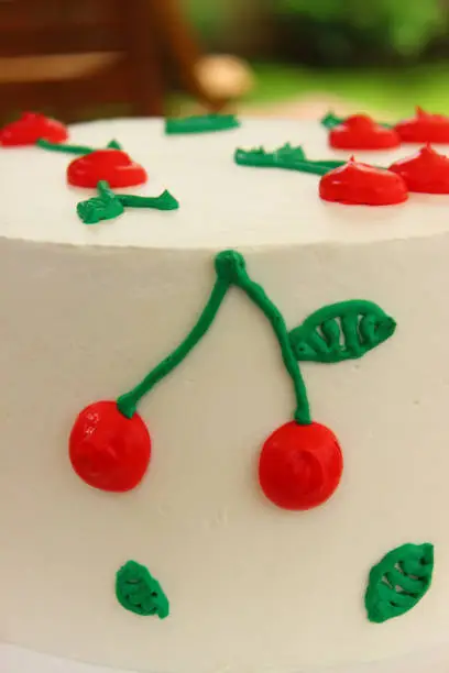 Cherries design on cake. Summer cake close caption.