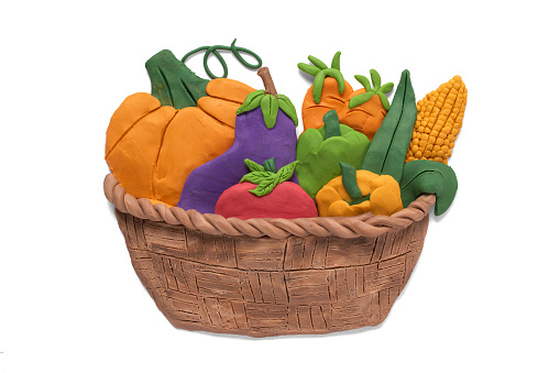 Basket with fresh healthy organic vegetables, handmade with plasticine, isolated on white background