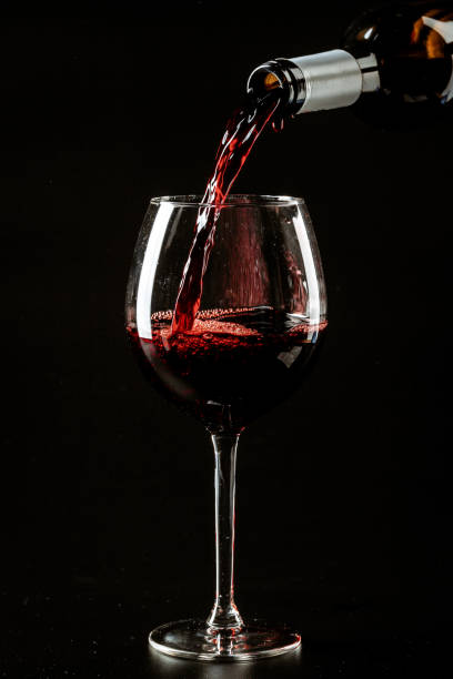 istock Red wine being poured in a wine glass on a dark background 1493051835