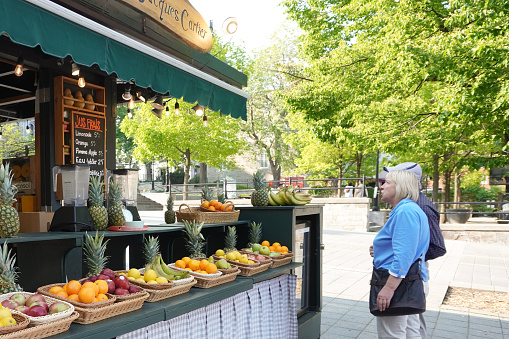 Montreal, Quebec, Canada - May 24, 2023: Elderly Couple Buying Fresh Fruits at Outdoor Market.