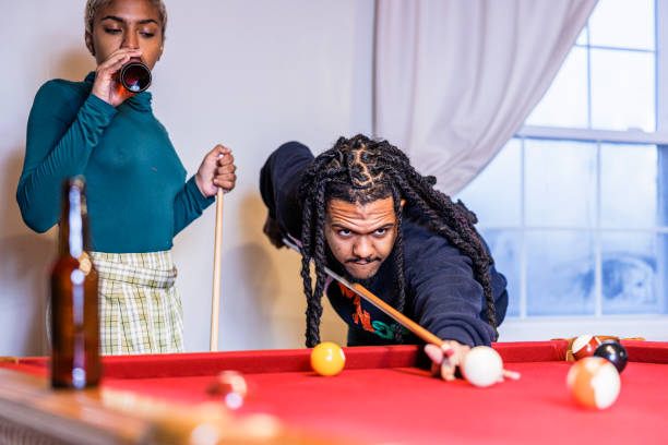 istock Winning Billiard streak: Dominican man with dreadlocks and beard showing off Pool game aptitude to his girlfriend at home biliard 1493053400