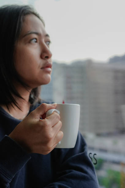 istock woman drinking coffee by the window 1493067358