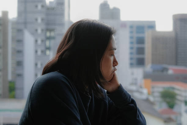istock woman standing at the window look outside 1493067893