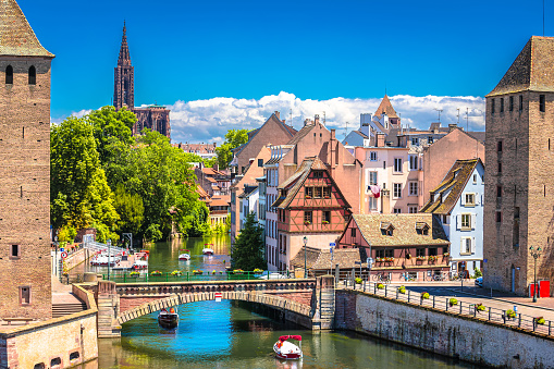 Picturesque half timbered buildings of shops, homes and cafes in the Petite France canal zone along the Ill river in the historic city of Strasbourg, in the Alsace region of France. The Maison des Tanneurs (tanners house) viewable on the riverbank