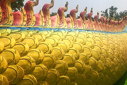 Close up of Naga scales or king of serpent scale colorful pattern texture used for decoration on naga statue which is related to faith, belief in Buddhism at temple in Thailand.