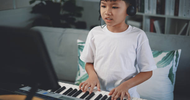 istock Cute boy enjoy to learning playing piano at home 1493073794