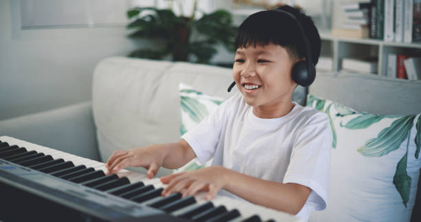 istock Cute boy enjoy to learning playing piano at home 1493073855