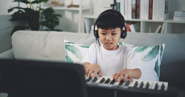 istock Cute boy enjoy to learning playing piano at home 1493073878