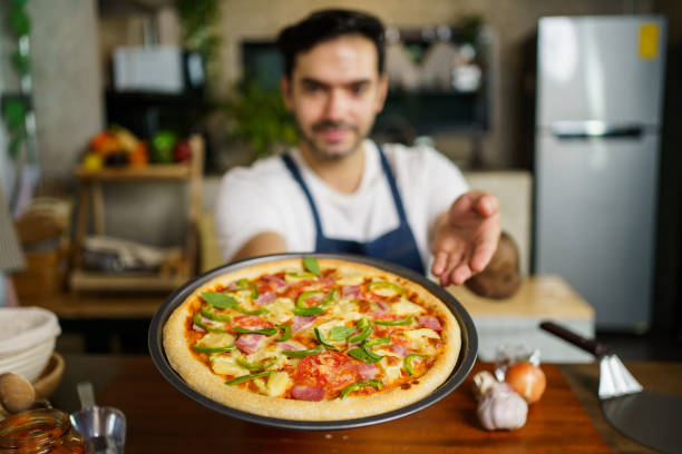 istock Man showing a baked pizza. 1493073943