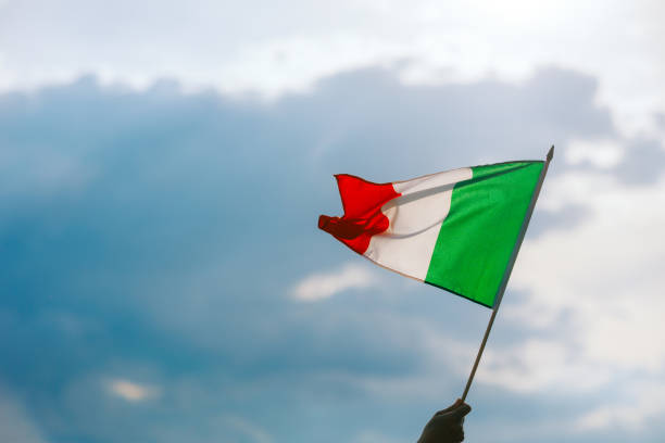 Agitant la main du drapeau de l’Italie sur un beau ciel - Photo