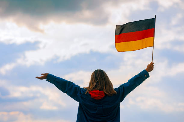 istock Woman Waving Germany Flag Looking at the Sky 1493074868