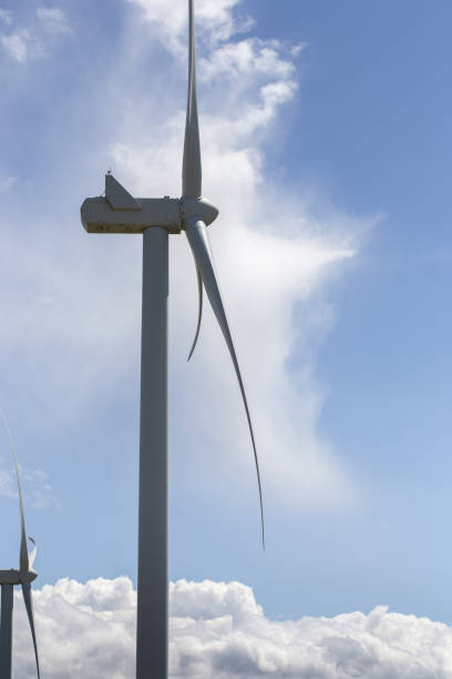 istock Windmill close-up of a blue sky with white fluffy clouds. 1493079105