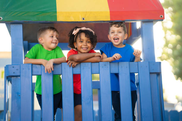 istock Three preschool children are happily playing and exploring on top of a playground structure, filled with excitement and wonder 1493081900