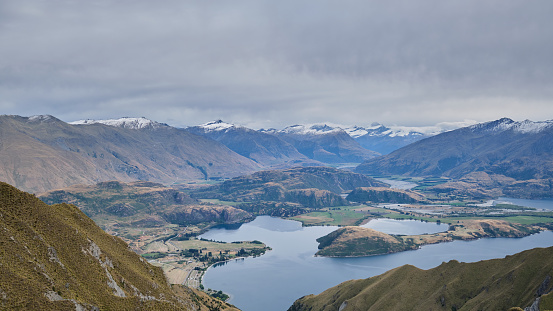 Roys Peak lookout overlooking Glendhu Bay and the surrounding mountain during a cloudy morning in March.