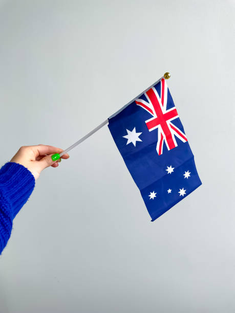 istock Woman's Hand holding Australia flag isolated on white background. 1493084576