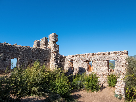 The ruins of Alanya old fortress with sharp, prickly outlines, weathered by time, stands under blue skies on a sunny day.