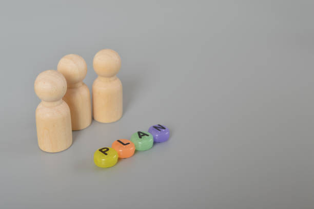 istock Wooden figures with text plan. Project management time planning in the business realm, symbolized by the interplay of gears and the diligent guidance of a businessman. Implementing business process management and automated workflow 1493089026