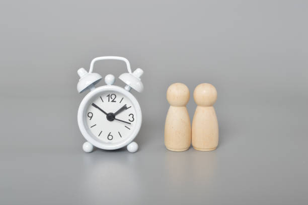 istock White clock and wooden figures. Project management, team work and time management concept 1493089028