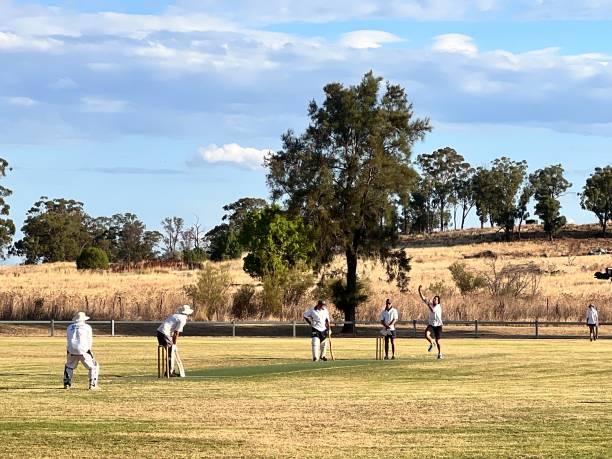 uomini australiani che giocano a cricket nel parco locale - sport of cricket village cricket player english culture foto e immagini stock