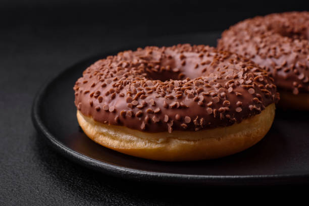 istock Delicious chocolate glazed donut sprinkled with chocolate chips 1493095925