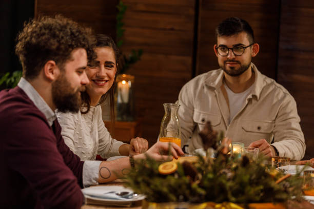 istock Group of young friends sitting at dining table, chatting, enjoying drinks and bonding during dinner party 1493096478