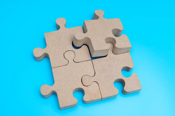 istock Wooden Jigsaw Puzzle parts on blue background. four puzzles form a rectangle on blue background. top view 1493097114